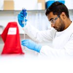 Cientista usando uma pipeta em um laboratório de pesquisa biomédica.