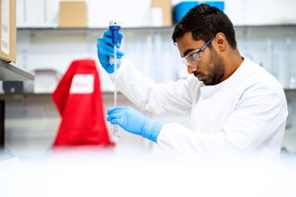 Cientista usando uma pipeta em um laboratório de pesquisa biomédica.
