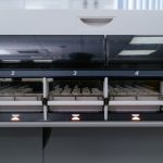 Máquina automatizada de laboratório analisando várias amostras em uma unidade de pesquisa em saúde.