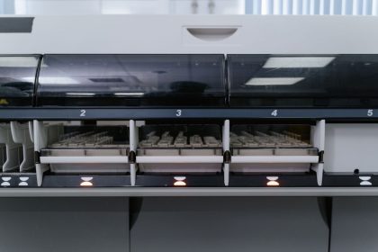 Máquina automatizada de laboratório analisando várias amostras em uma unidade de pesquisa em saúde.