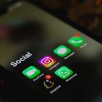 Close-up de uma tela de smartphone exibindo ícones de aplicativos de redes sociais.