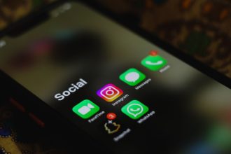 Close-up de uma tela de smartphone exibindo ícones de aplicativos de redes sociais.