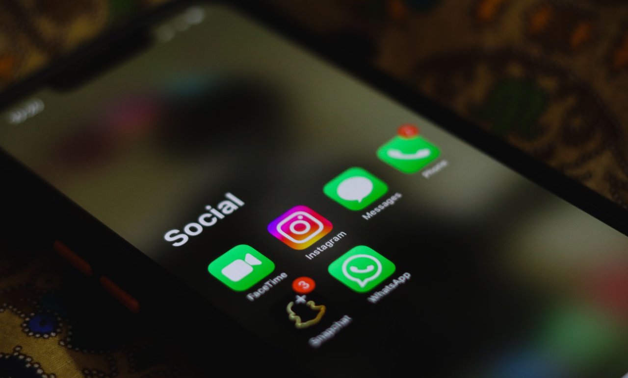 Close-up de uma tela de smartphone exibindo ícones de aplicativos de redes sociais.