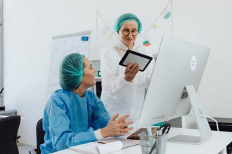 Duas pesquisadoras discutem um projeto em um tablet dentro de um laboratório.