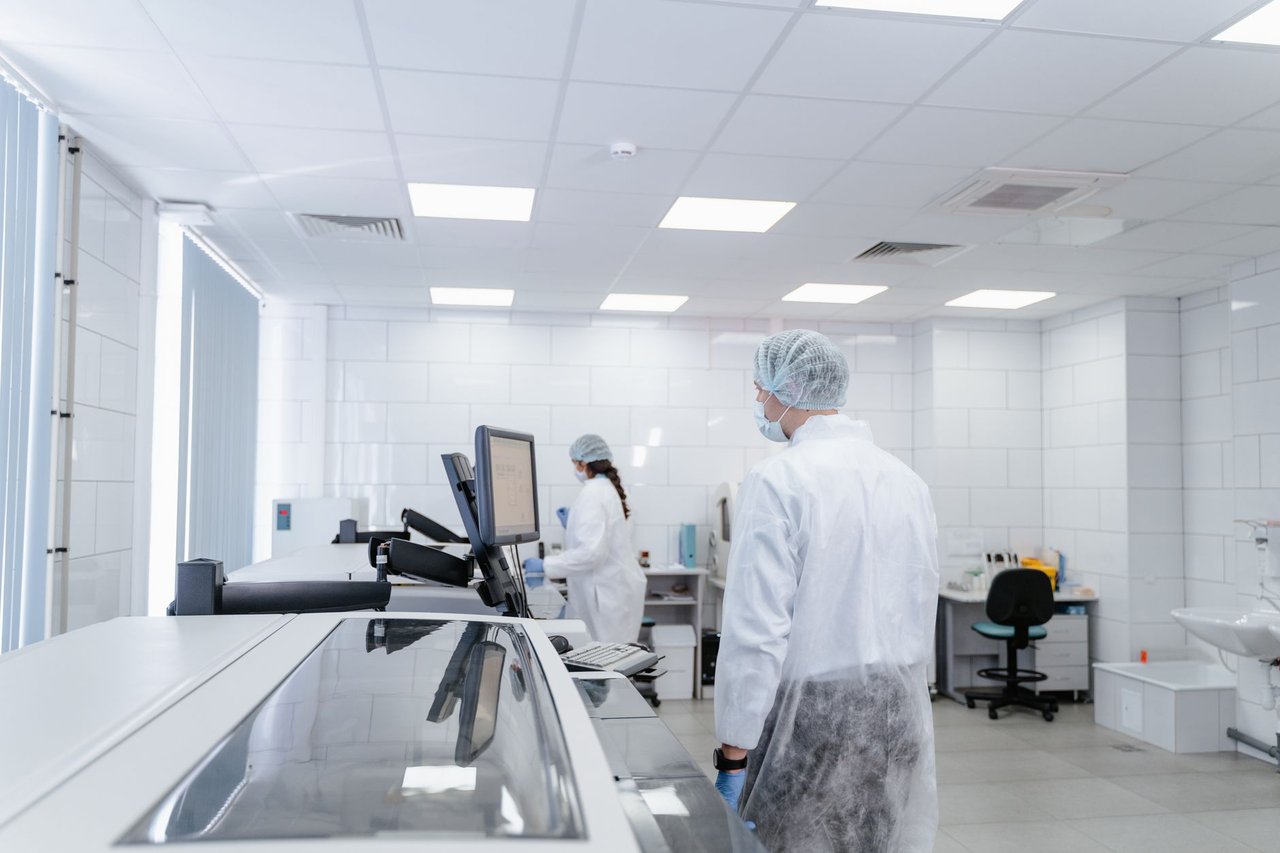 Profissionais de laboratório realizam pesquisas em um ambiente moderno e equipado.