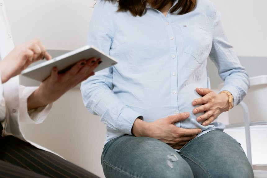 Gestante conversa com profissional de saúde durante uma consulta de pré-natal.